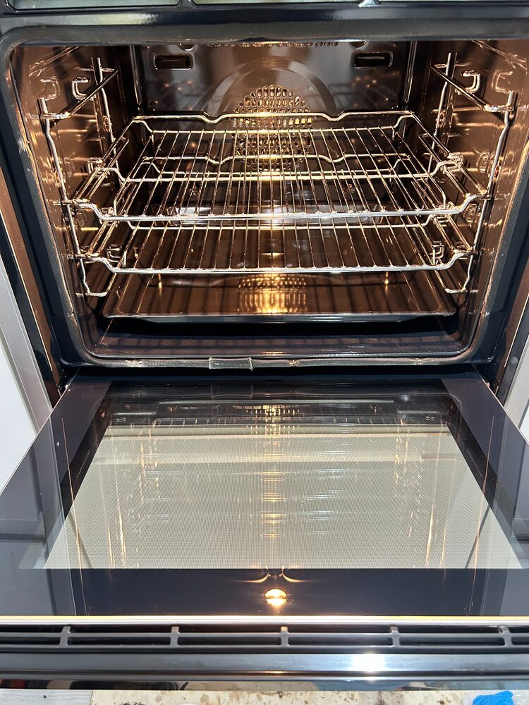 Freshly cleaned oven interior with polished racks and tray